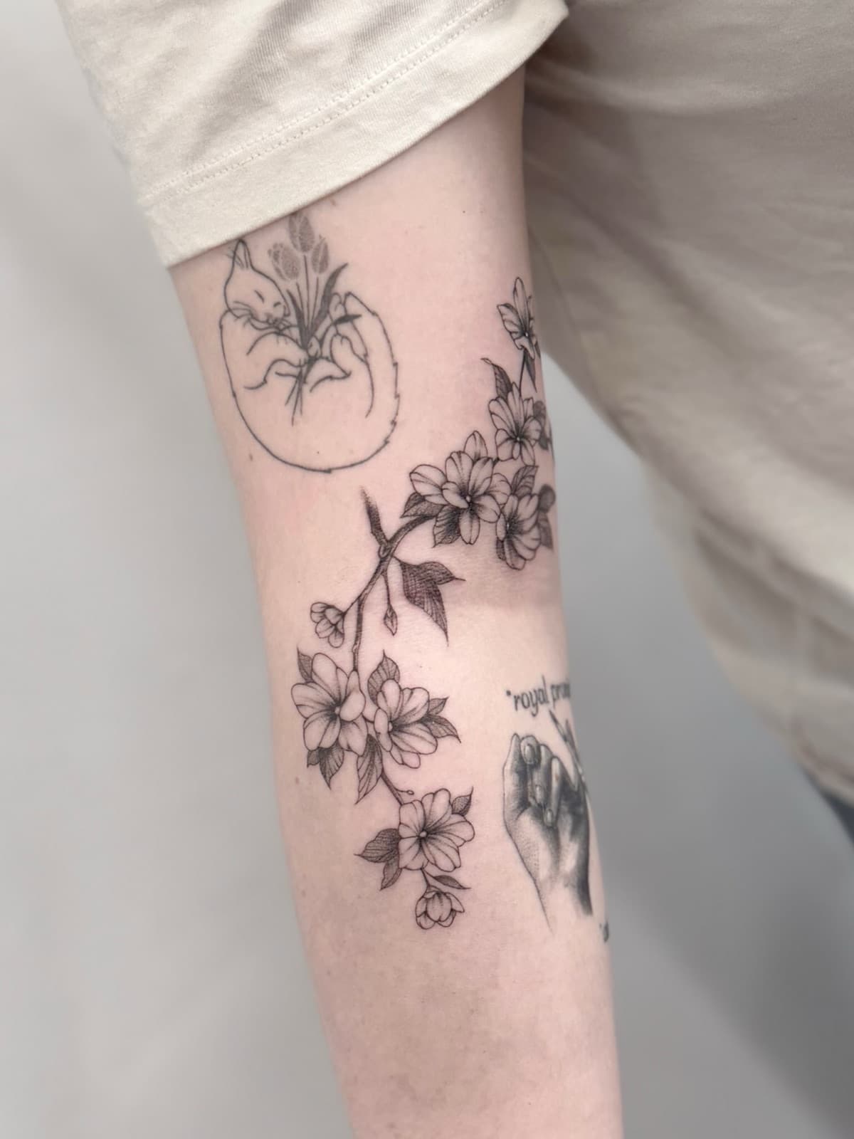 Fine line cherry blossom branch on the forearm