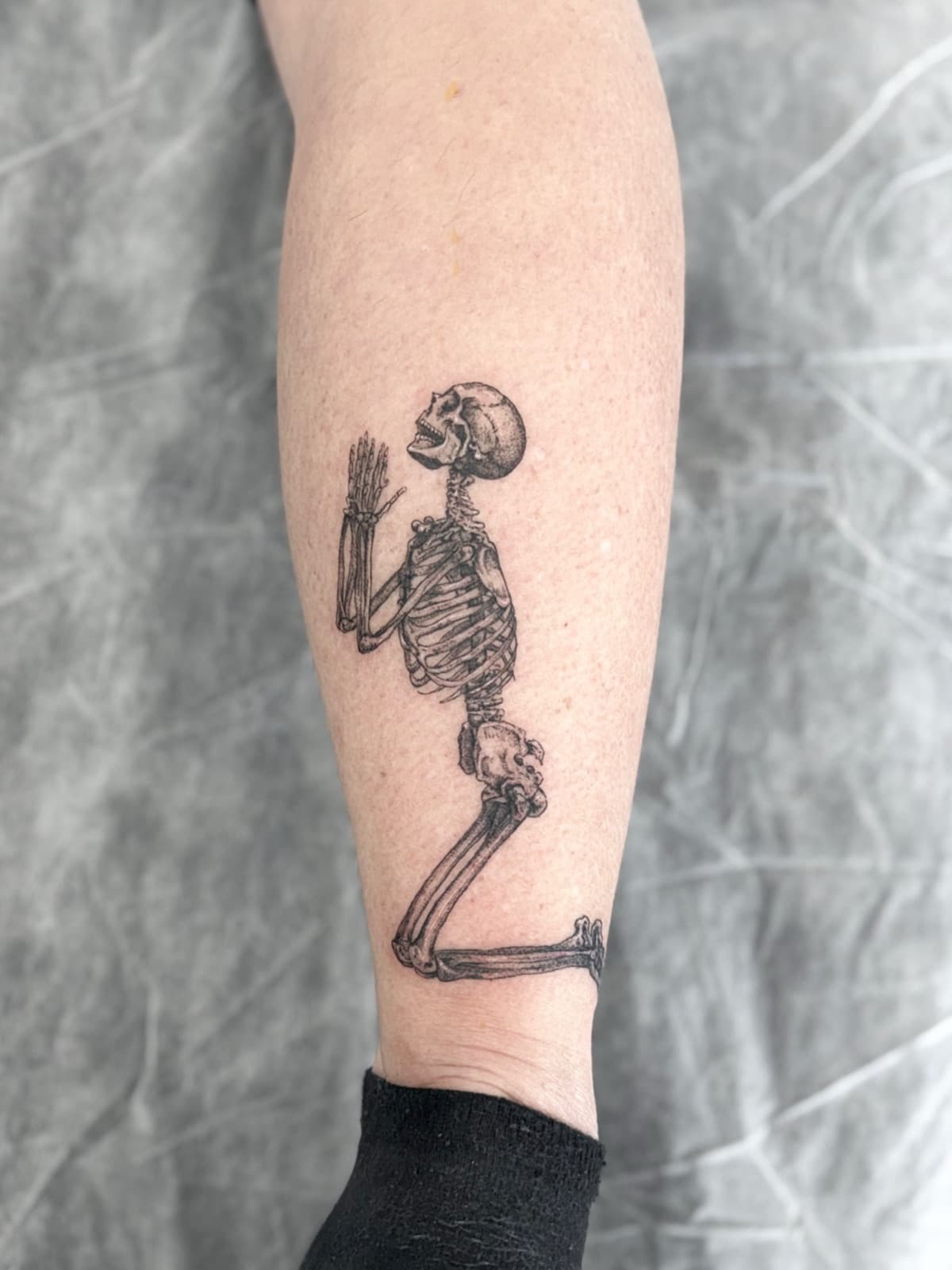 Praying skeleton in fine line black and grey, shin