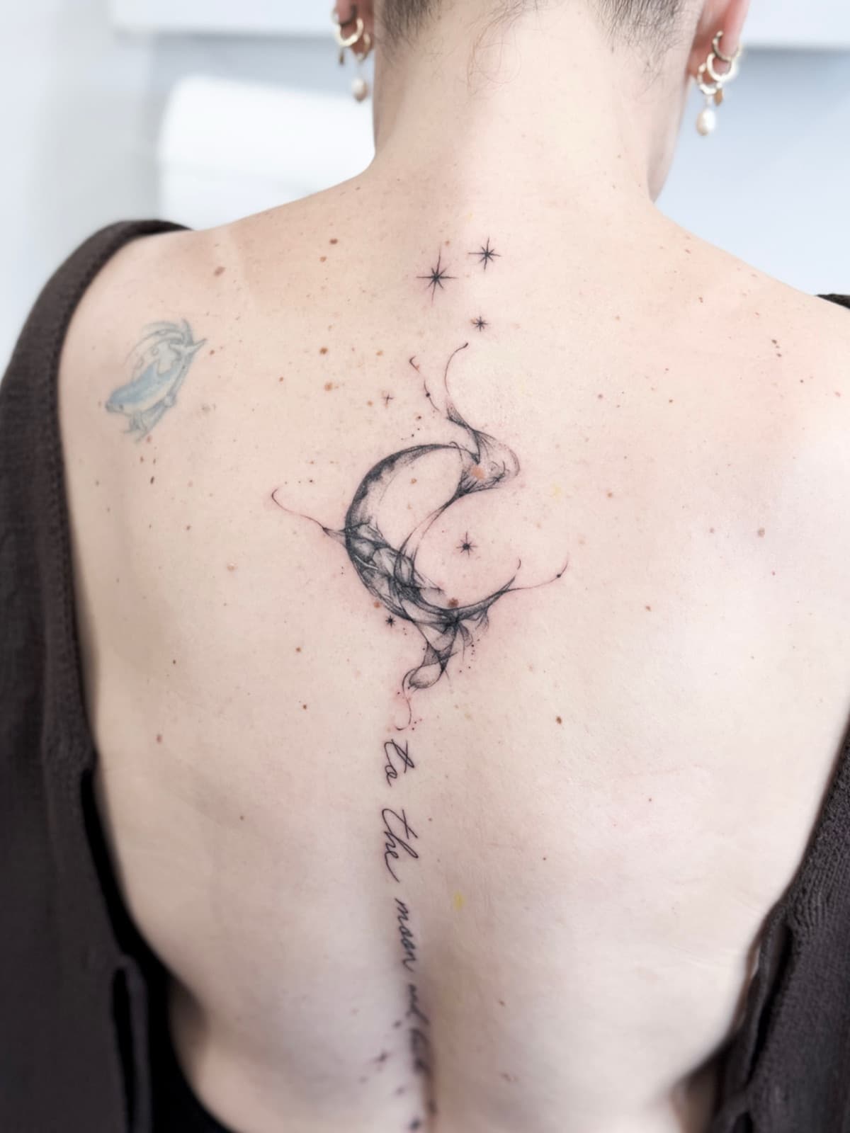 Smoky crescent moon and stars with script down the spine