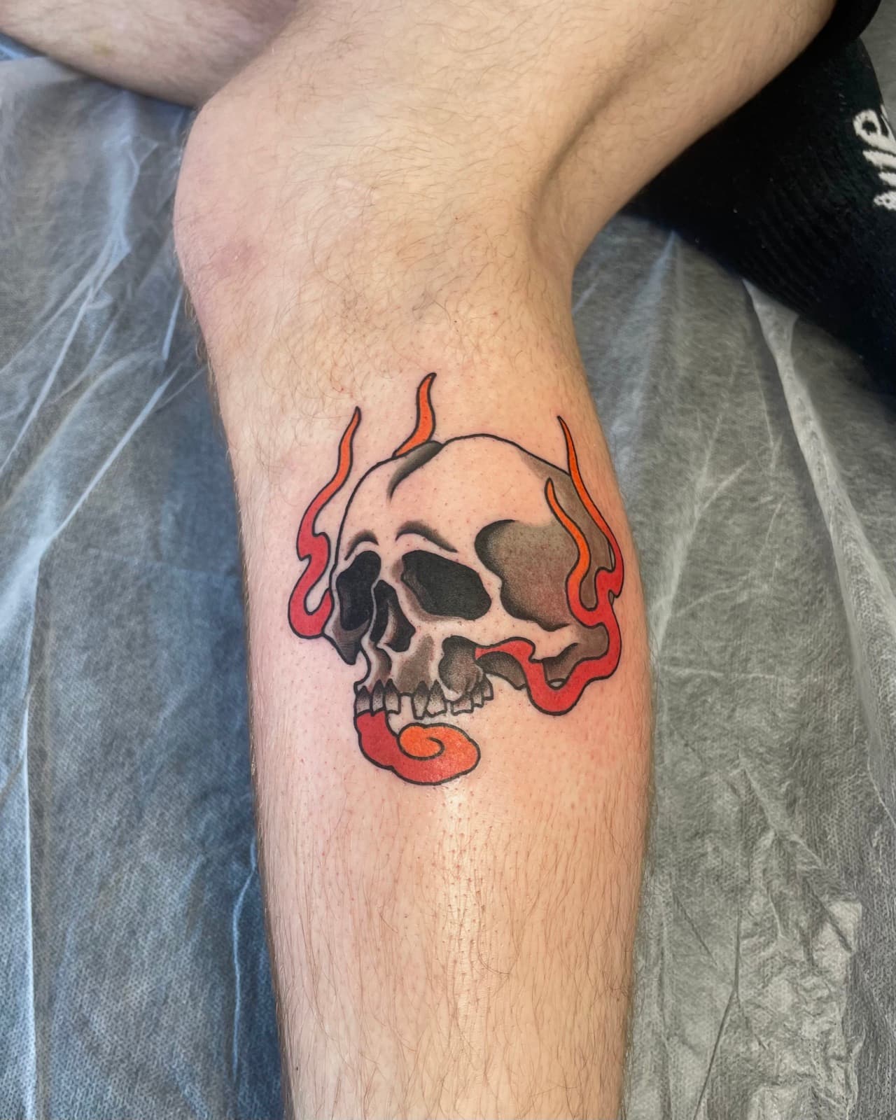 Bold traditional skull with red flames, calf