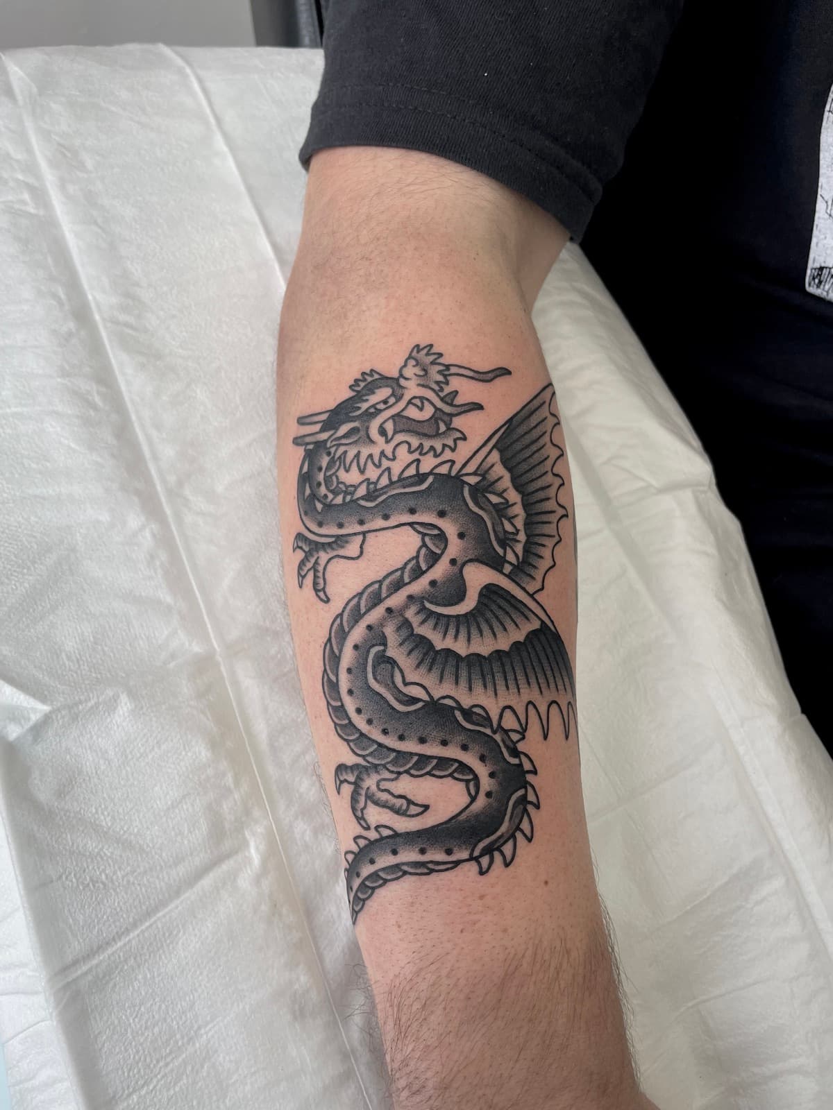 Bold black and grey traditional dragon, forearm