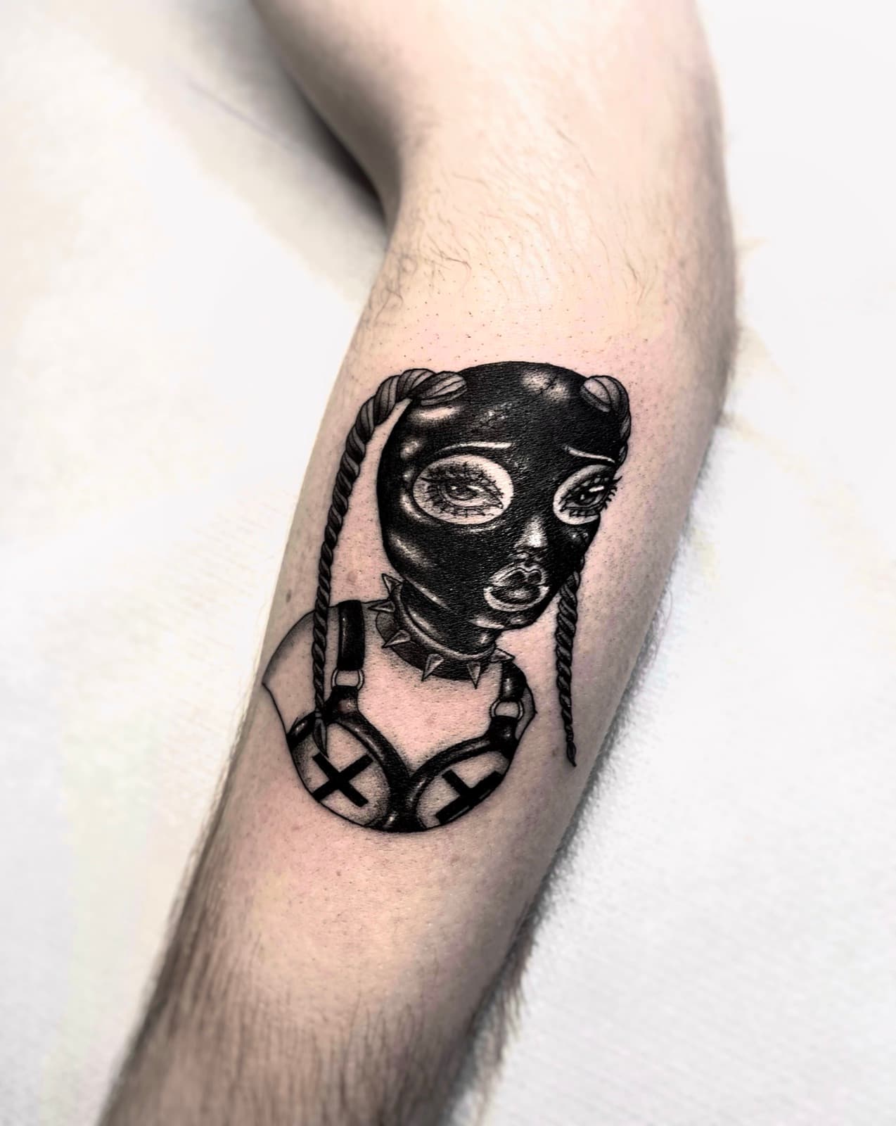 Blackwork doll in a mask and harness, forearm