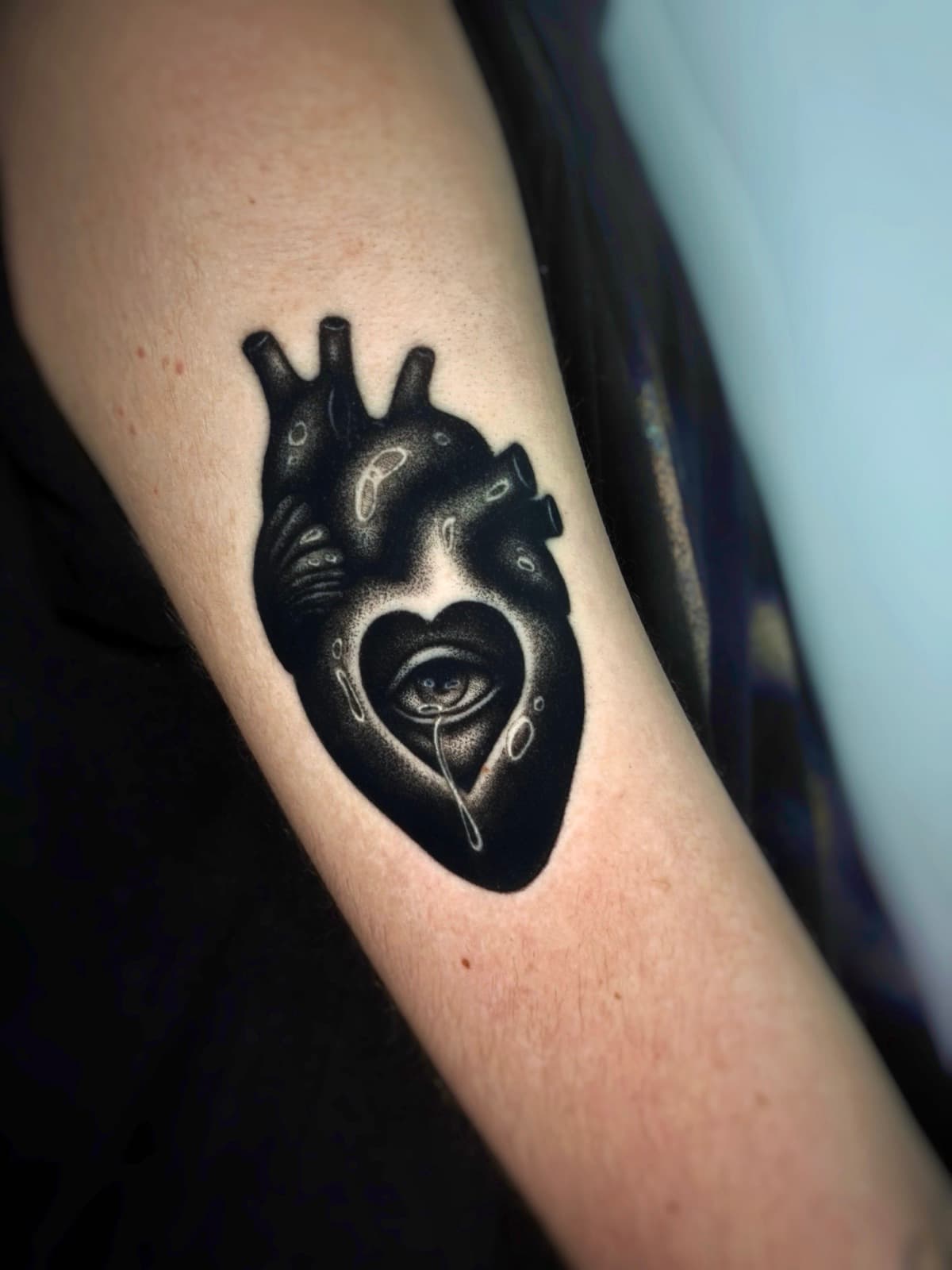 Solid blackwork anatomical heart with a crying eye