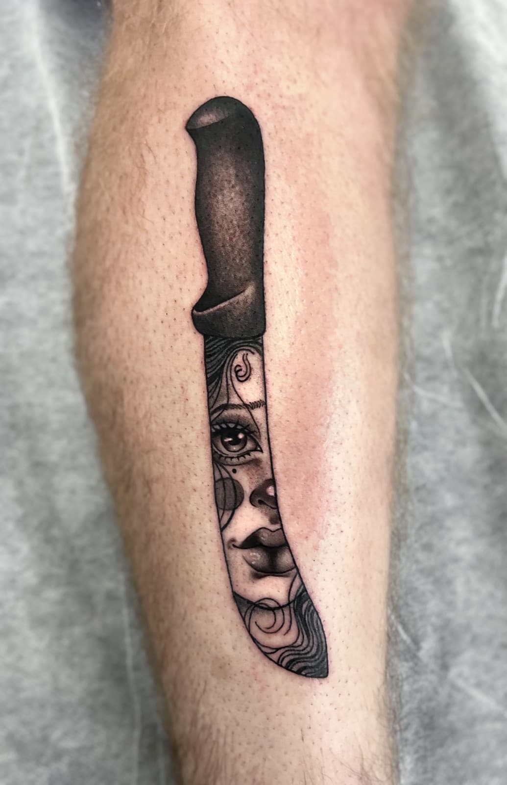 Blackwork cleaver with a woman's face in the blade, calf