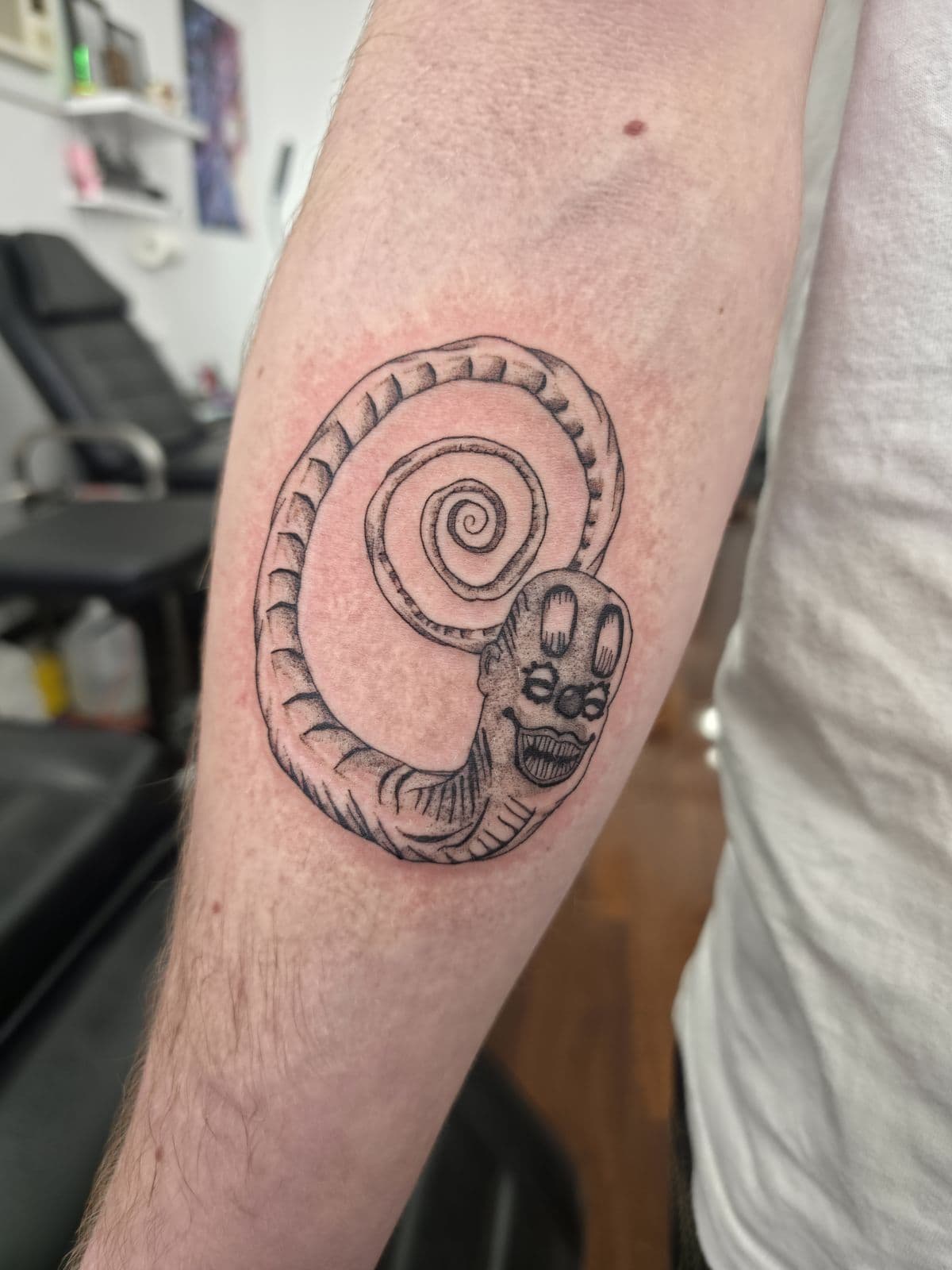 Spiral creature in fine linework, forearm