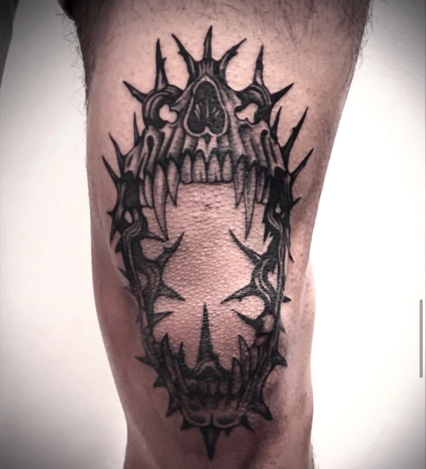 Blackwork skull and thorns knee tattoo
