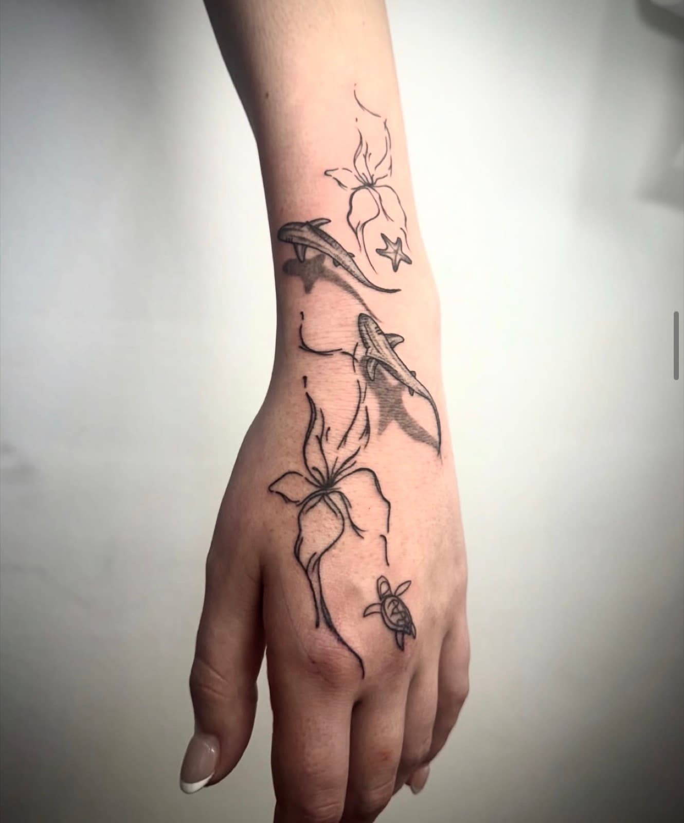 Fine line shark, turtle and hibiscus hand tattoo