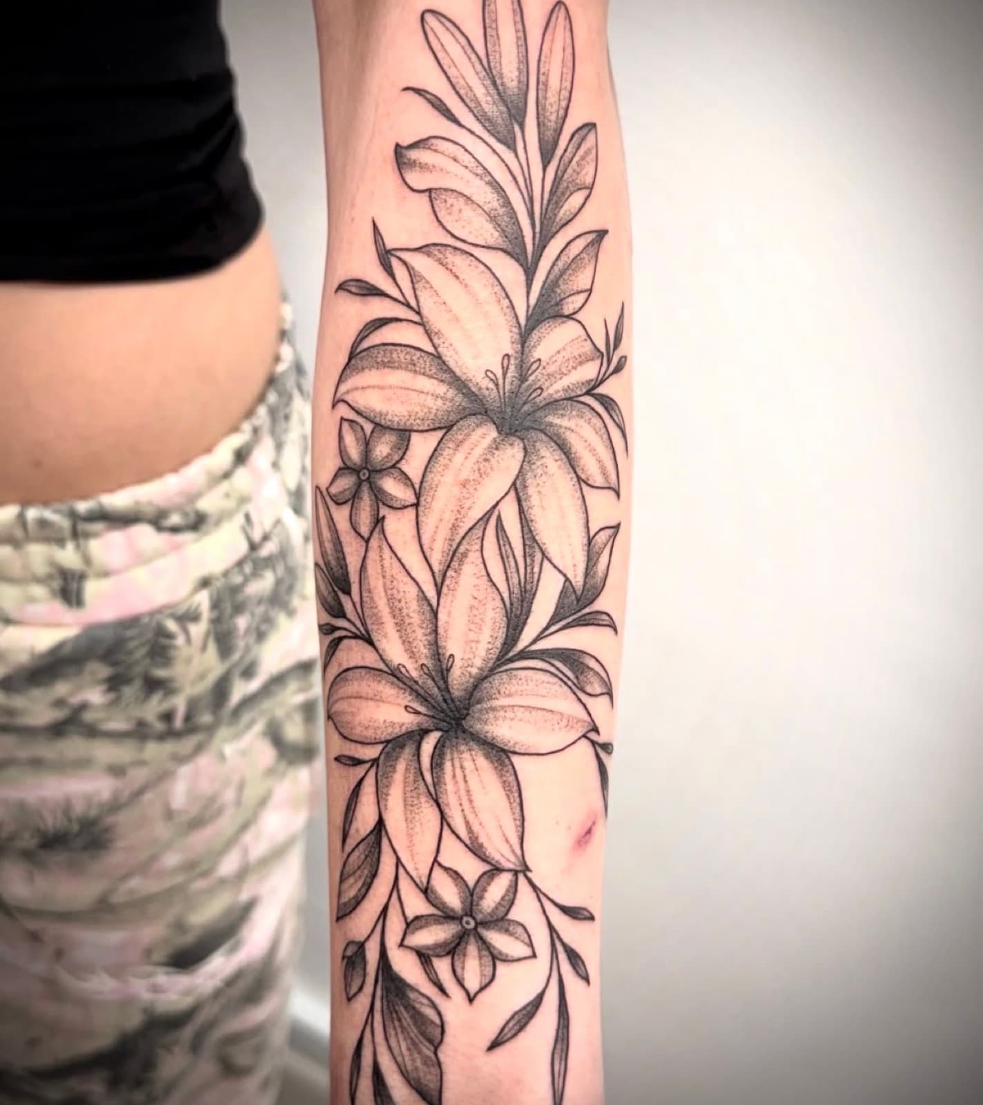 Fine line lilies and blossoms forearm piece
